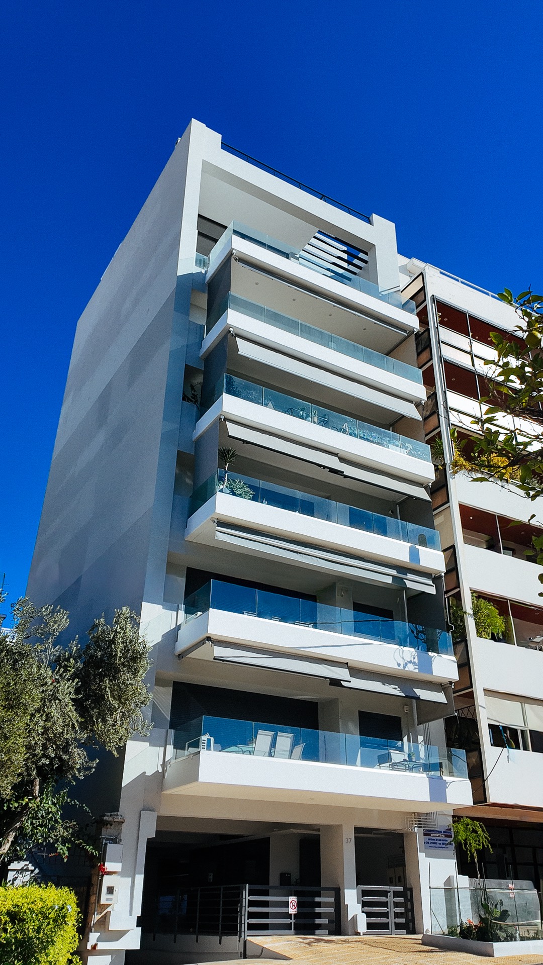 Η οικοδομή Ορφανίδου 37 — η επταώροφη όψη με τα κρυστάλλινα στηθαία από το επίπεδο του δρόμου.