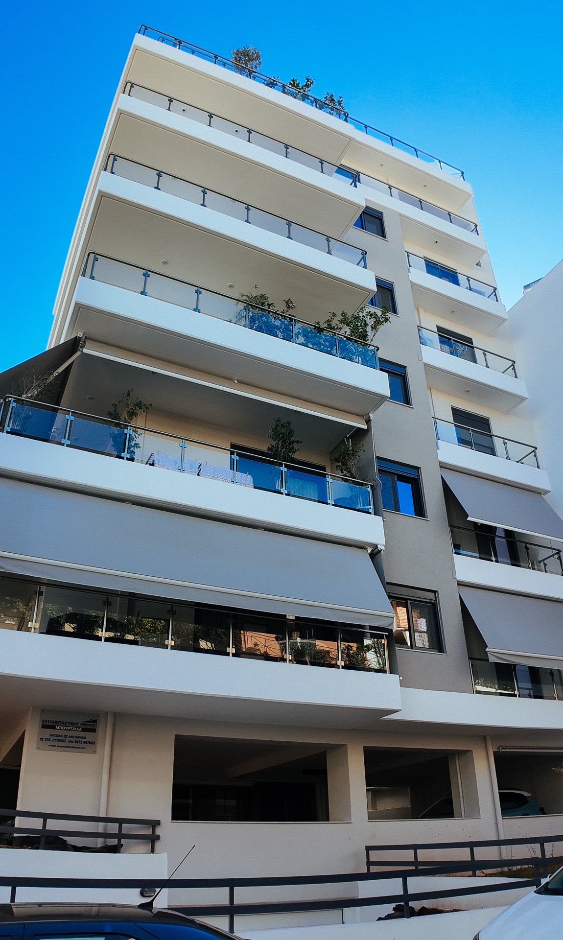 Η οικοδομή Τεώ 82 — η γωνιακή επταώροφη όψη από το επίπεδο του δρόμου.